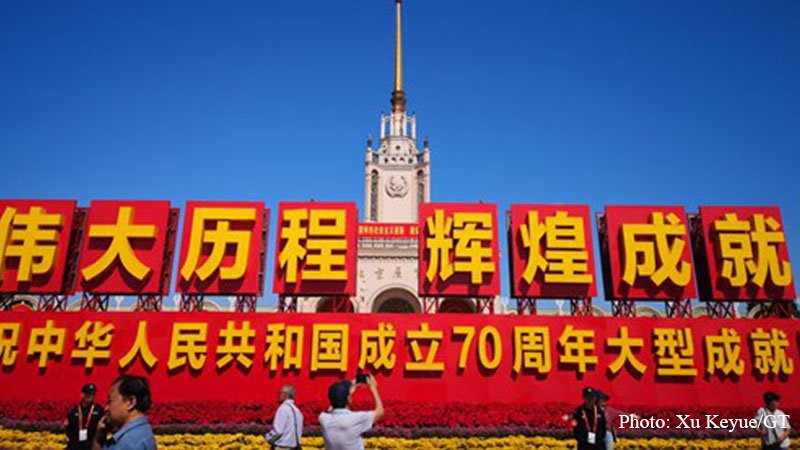 Visitors walk past Beijing Exhibition Center, where an exhibition opened to the public on Tuesday to celebrate the 70th anniversary of the founding of the People's Republic of China