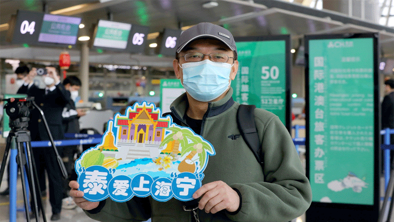 A tourist holds a sign that reads Thailand loves Shanghai people at a Shanghai airport on February 6, 2023. A tour group departed from the airport and flew to Thailand's Phuket, one of the first Chinese tour groups to head abroad following China's resumption of outbound group tours. Photo: Chen Xia/GT