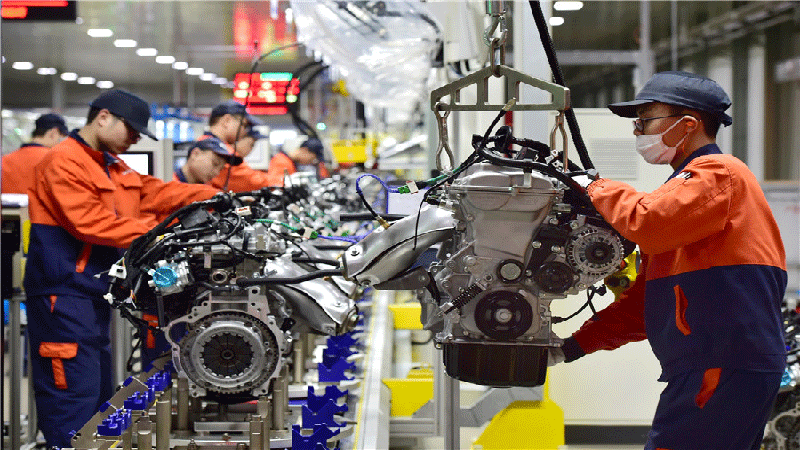 Employees work on the production line of Geely Auto's engine manufacturing unit in Yiwu, Zhejiang province. [Photo by Lyu Bin/For China Daily]