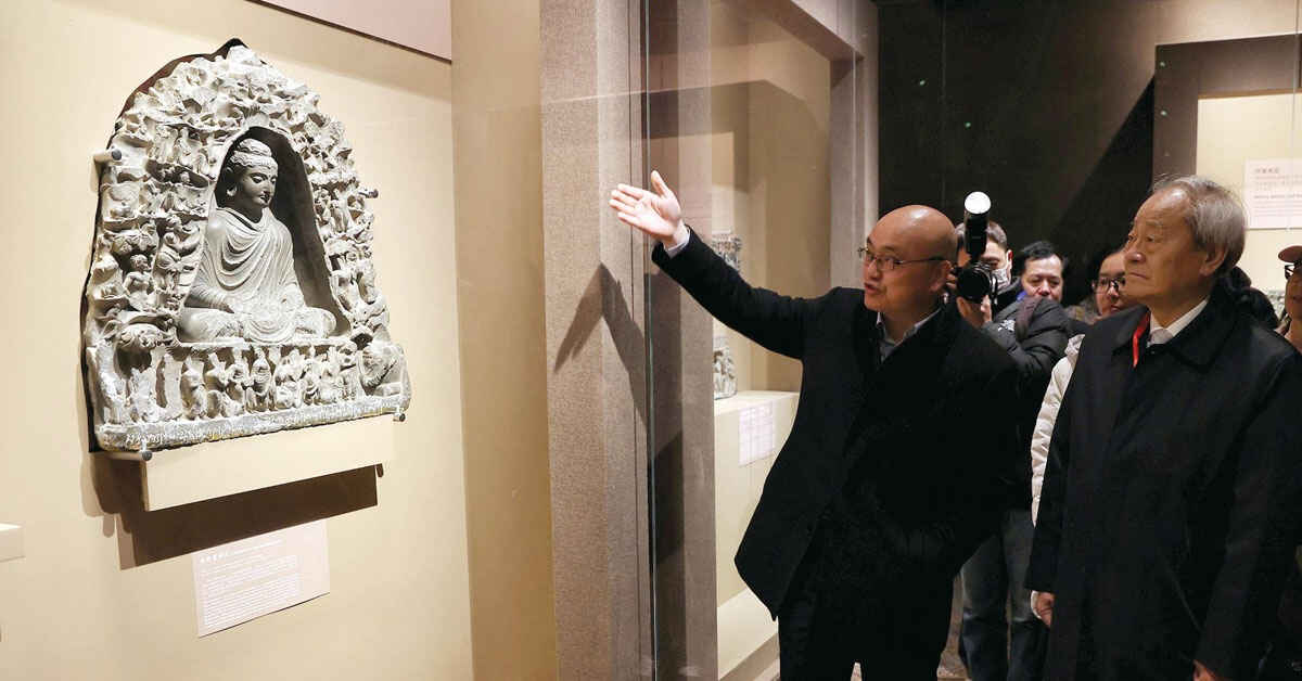 Curator Luo Wenhua (first from left) introduces a stone carving to visitors at the exhibition, Gandhara Heritage Along the Silk Road, in the Palace Museum in Beijing on March 15. (JIANG DONG / CHINA DAILY)
